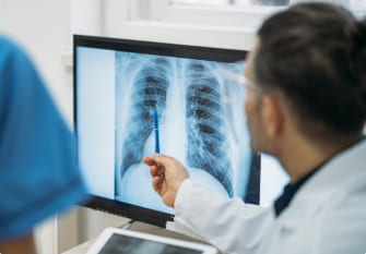 A doctor points to an X-ray of the lungs on a computer screen